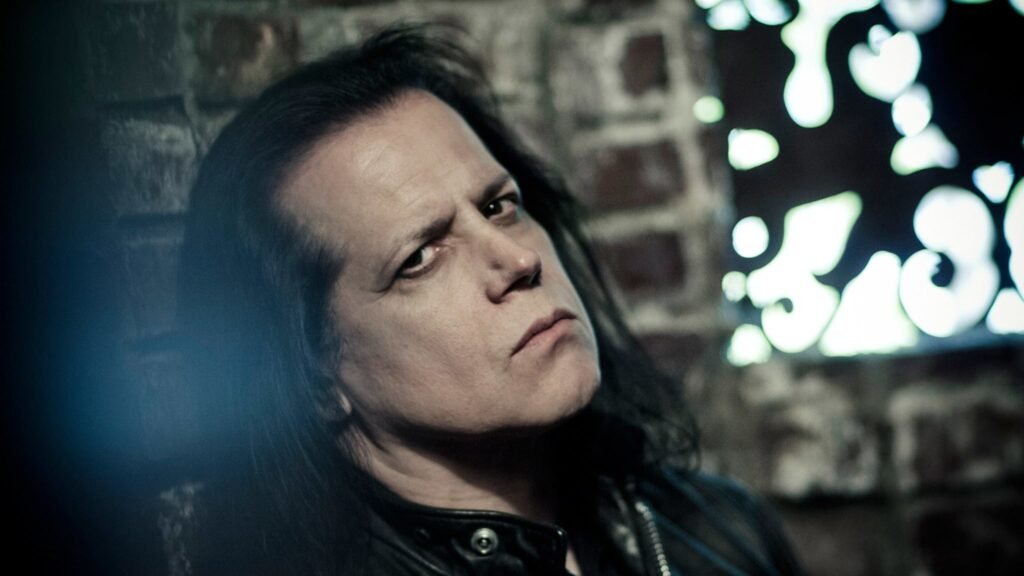 Glenn Danzig in a moody portrait, long dark hair and leather jacket, official promotional photo