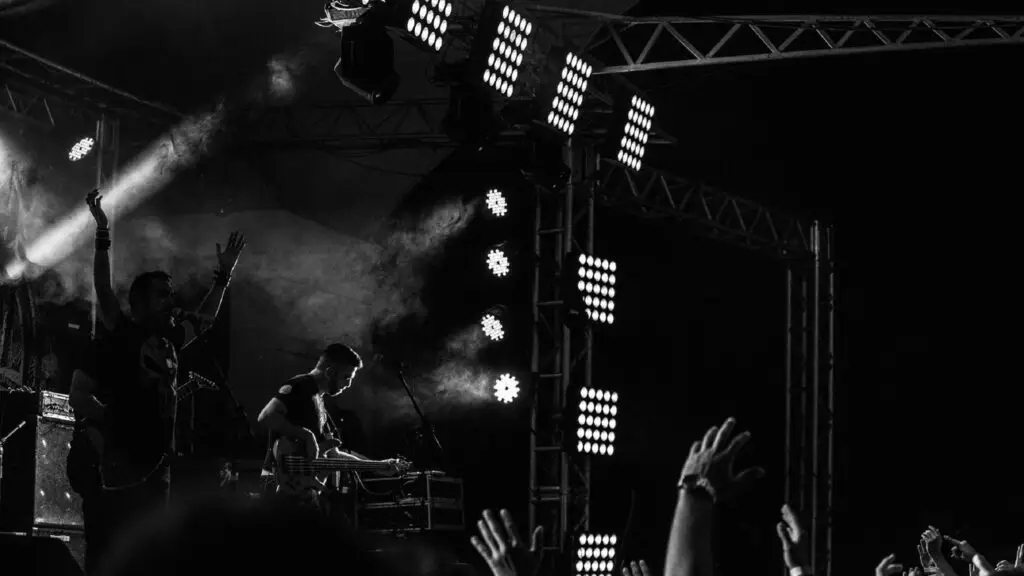 Dax performing live on stage with crowd hands raised and dramatic stage lighting