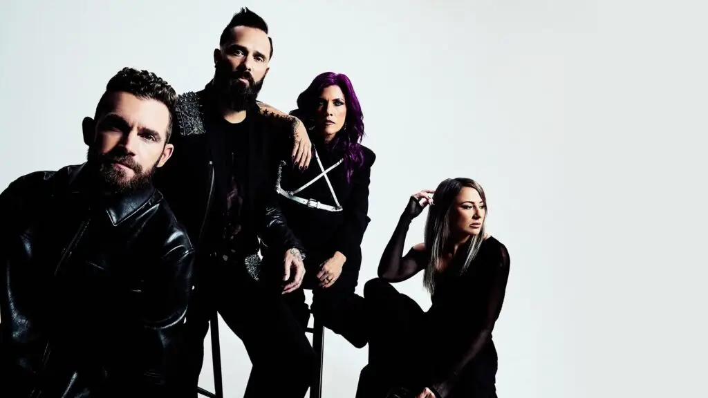 Skillet band promo photo showing all four members in black against white backdrop
