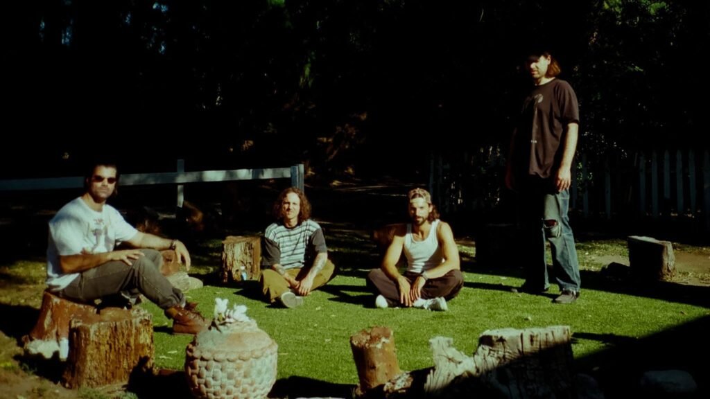 Turnover band members in an outdoor promotional photo for their 2026 Down on Earth Tour