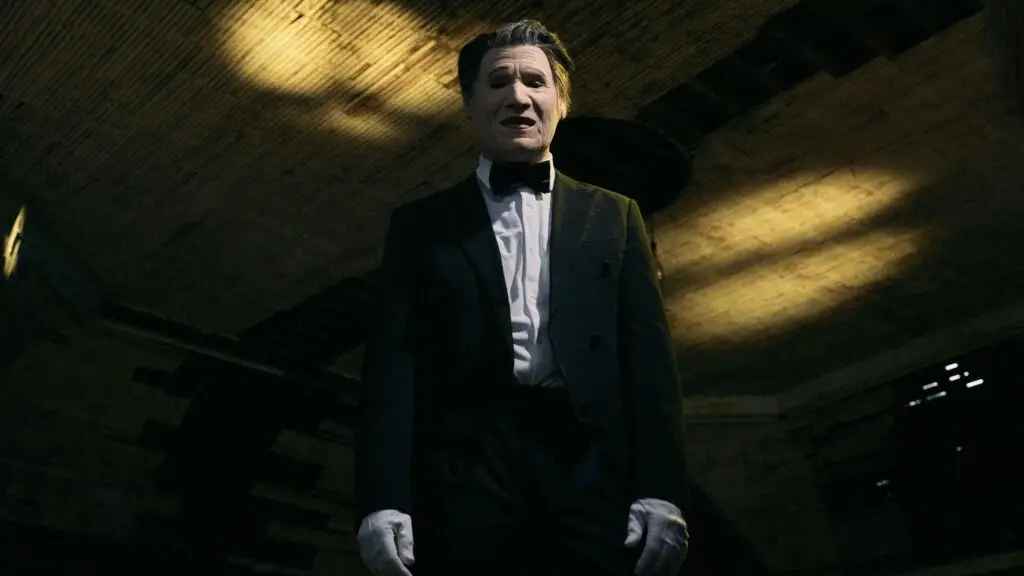 PRESIDENT vocalist performing masked in tuxedo and white gloves under dramatic golden spotlight