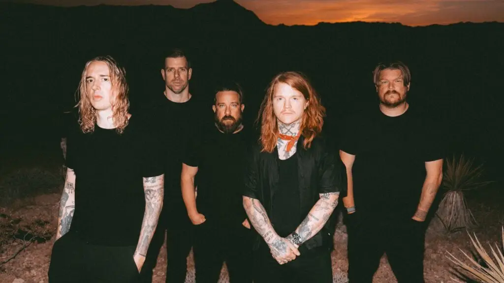 Underoath band press photo, five members in black at desert dusk, Define the Great Line 20th Anniversary Tour