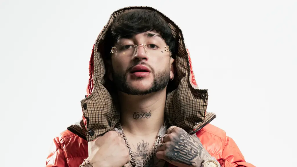 Calle 24 (Diego Millán) official press photo, corrido tumbado singer in orange puffer jacket