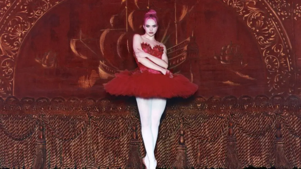 ADÉLA in red ballet tutu and pink hair, theatrical promo photo for The Red Bottoms Tour 2026