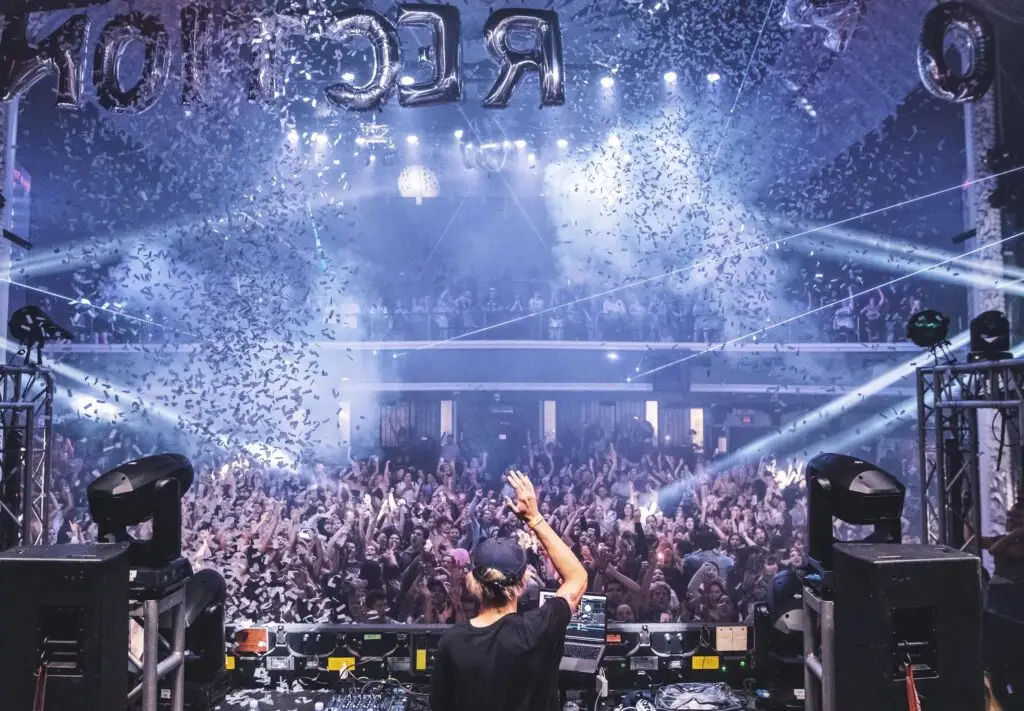 Club 90s DJ performing at packed dance event with confetti and crowd at House of Blues Houston