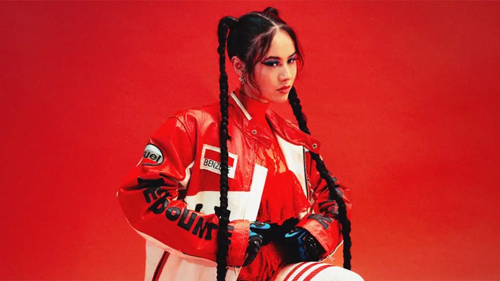 Emei in a red racing jacket and braided pigtails, official press photo for the Night at the Opera Tour