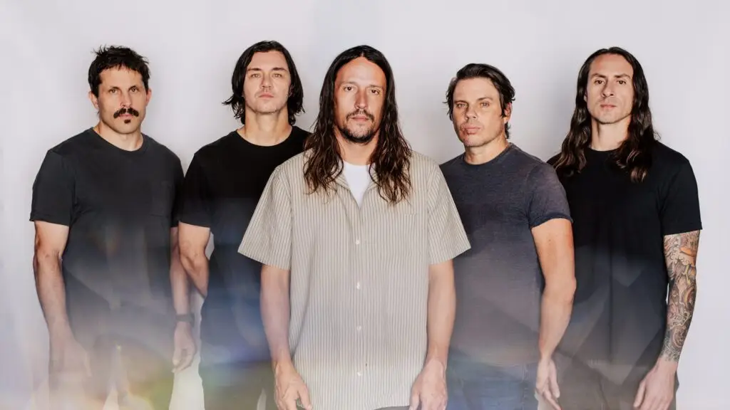 Saosin five-piece band press photo — Cove Reber centered with four bandmates, studio backdrop