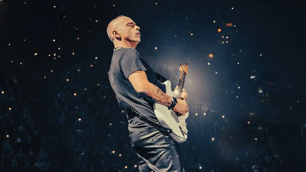 Eros Ramazzotti performing live with electric guitar at large arena concert