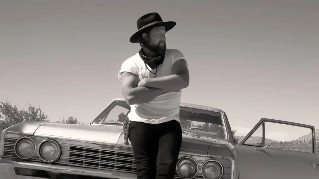 Zach Williams leaning against a classic car in a B&W press photo for the Revival Nights Tour 2026