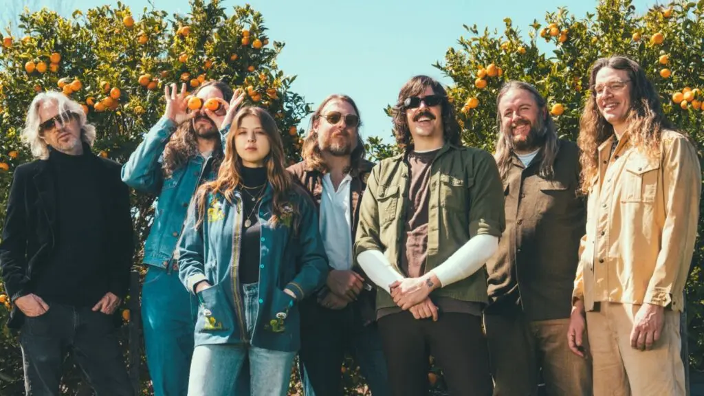 Grateful Shred band press photo in sunlit citrus grove, seven members in California sunshine